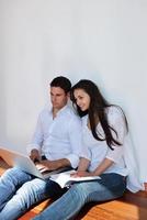 relaxed young couple working on laptop computer at home photo