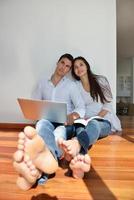 relaxed young couple working on laptop computer at home photo