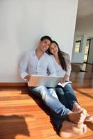 relaxed young couple working on laptop computer at home photo