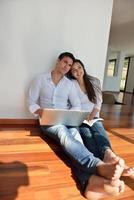 relaxed young couple working on laptop computer at home photo