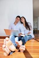 relaxed young couple working on laptop computer at home photo