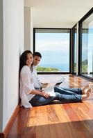 relaxed young couple working on laptop computer at home photo