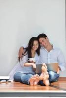 relaxed young couple working on laptop computer at home photo