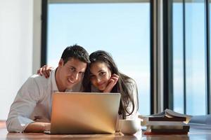 relaxed young couple working on laptop computer at home photo