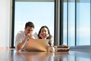 relaxed young couple working on laptop computer at home photo