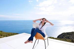 relaxed young woman at home working on laptop photo