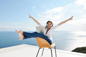 relaxed young woman at home working on laptop photo