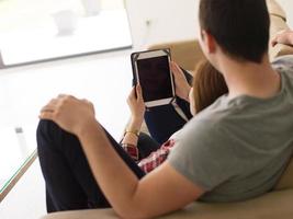 pareja relajándose en casa con tabletas foto