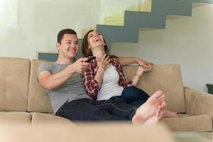 Young couple on the sofa watching television photo