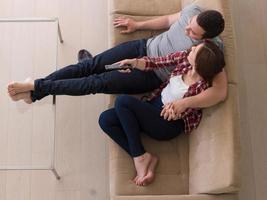 Young couple on the sofa watching television photo