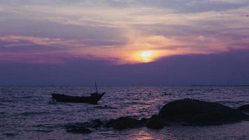 Silhouette of a fishing boat in the left of the picture, in the evening there is a sunset at the sea. photo