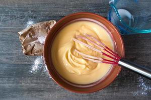 Mixing vanilla pudding with ingredients on rustic table Flat lay photo