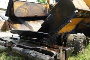 asphalt finisher, front detail of yellow asphalt road construction machine parked on the side of the road photo