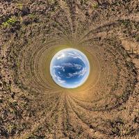 inversión de la transformación del pequeño planeta del panorama esférico 360 grados. vista aérea abstracta esférica en el campo con impresionantes nubes hermosas. curvatura del espacio. foto