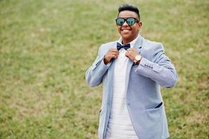 Stylish arabian man in jacket, sunglasses and bow tie posed outdoor. Arab model boy. photo