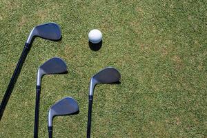 Golf club and golf ball on green grass photo