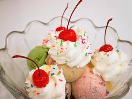 Ice cream scoops with cherry and whipped cream photo