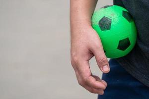 The Green Rubber football toy was held in the male's hand photo