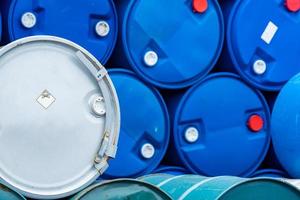 Old chemical barrels. Blue and green oil drum. Steel and plastic oil tank. Toxic waste warehouse. Hazard chemical barrel with warning label. Industrial waste in drum. Hazard waste storage in factory. photo