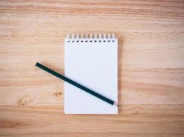 Pencil and Notepad on the wooden desk photo