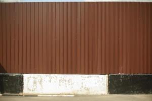 White and black curb on the background of a brown fence. photo