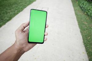 rear view of young man using smart phone at outdoor photo