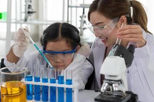 Child Learn Chemistry and Science in Laboratory with Teacher photo