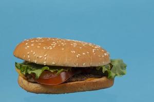 primer plano de hamburguesa clásica sobre un fondo azul. foto