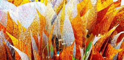 Close up silver and golden leaves for background at Thai temple. Group of object for respect holy, monk statue. Pattern of colorful leaf wallpaper photo