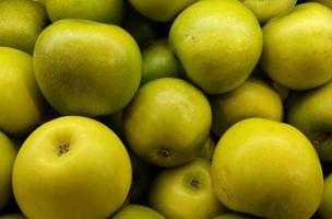 Close up pile of green apples in supermarket. Healthy vegetarian fruit photo isolated on landscape template. A bunch of sweet fruits.