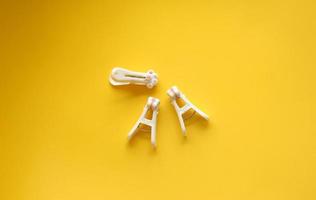 Cute and kawaii cat paw designed clothes pins for hanging clothes or photos polaroid. Object isolated on yellow background.