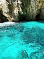 Turquoise water vertical image where there is a natural rocky formation. photo