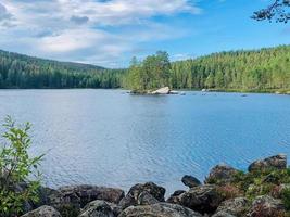 Landscape of a nature reserve in Sweden where there is a lake surrounded by pine trees. photo