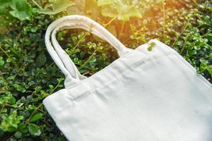 Tote blanco tela de lona bolsa ecológica saco de compras de tela sobre fondo de naturaleza de hoja verde foto