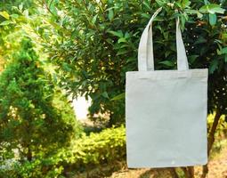 Tote blanco tela de lona bolsa ecológica saco de compras de tela sobre fondo de naturaleza de hoja verde foto