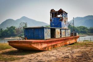 old boat on the riverside ancient ship decay steel with rust metal iron photo