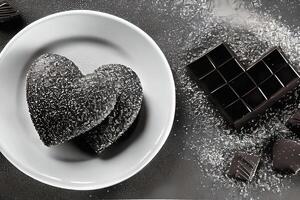 Love shape Chocolate cake on the plate and chocolate bar with sugar topping. Black and white. photo