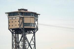 Low angle view of Torre Sant Sebastia with cables and restaurant under clear sky photo