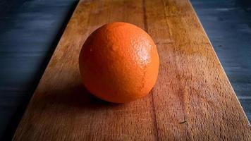 slicing orange on a kitchen board photo