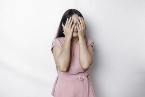 Shy Asian woman hiding face laughing timid. Cute woman smiling happy through hands, isolated white background. photo