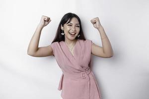 A young Asian woman with a happy successful expression wearing pink blouse isolated by white background photo