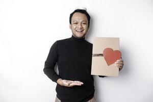 hermosa joven asiático hombre vistiendo negro camisa participación regalo caja rojo corazón, San Valentín día concepto. foto
