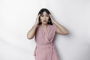 un retrato de un asiático mujer vistiendo un rosado blusa aislado por blanco antecedentes mira Deprimido foto
