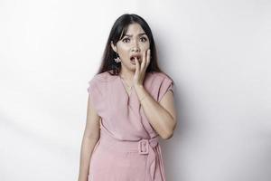 Young Asian woman isolated on white background, looks depressed, face covered by fingers frightened and nervous. photo