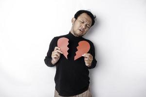 Beautiful young Asian man expressed his sadness while holding broken heart isolated on white background photo