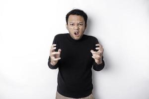 el enojado y enojado cara de asiático hombre en negro camisa aislado blanco antecedentes. foto