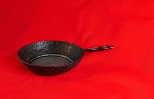 An old cast iron skillet made in circa 1960 against a red background. photo