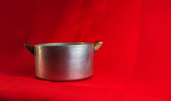 An old aluminum pan made in circa 1960 against a red background. photo