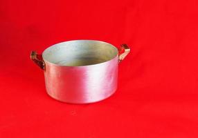 An old aluminum pan made in circa 1960 against a red background. photo