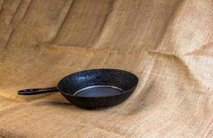 An old cast-iron skillet made in circa 1960 with burlap in the background. photo